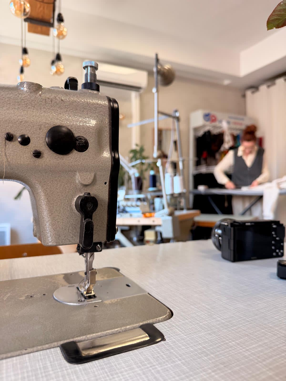 L'atelier de Gwenola avec sa machine à coudre vintage et un tissu posé sur une table en bois